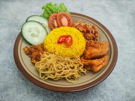 Nasi Kuning, ein traditionelles indonesisches Essen. Gelber Reis mit Nudeln, geschreddertem Huhn und Gemüse