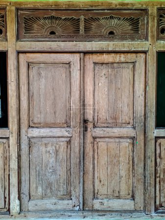 Foto de Antiguo y sin recubrimiento de tallar puerta de madera en la casa tradicional de Java de Indonesia - Imagen libre de derechos