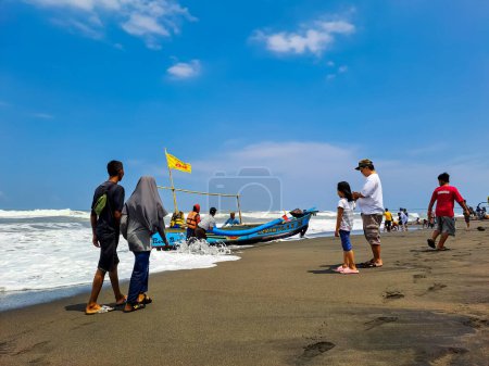 Photo for The enthusiast of the local tourist to approach the fishing boat that just returned from the sea to buy the fisherman's catches. Yogyakarta, Indonesia - April 23, 2023 - Royalty Free Image