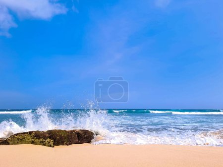 Photo for View of beautiful beach with white sand, rocks and calm waves under clear blue sky. Summer vacation concept. Ngudel Beach, Malang, Indonesia - Royalty Free Image