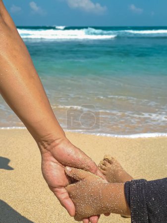 Foto de Vista de cerca de padre e hijo tomados de la mano en la playa. Confianza familiar, apoyo y concepto de cuidado - Imagen libre de derechos