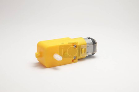Foto de Una caja de cambios amarilla vista lateral del motor sobre un fondo blanco. Materiales de bricolaje para el aficionado a la electrónica - Imagen libre de derechos