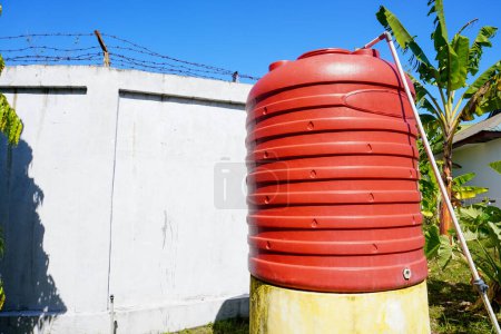 Photo for Low angle view of orange water big tank under the blue morning sky - Royalty Free Image