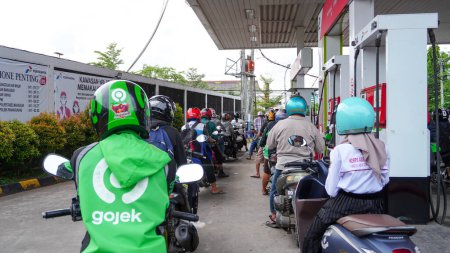 Foto de Makassar, October 27, 2022: Motorbikes queue waiting to buy fuel at Pertamina fuel stations when drivers panic to buy fuel - Imagen libre de derechos