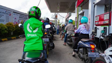 Foto de Makassar - Indonesia, 27 de octubre de 2022: Estaciones de servicio o gasolineras ocupadas para hacer cola para cargar combustible vehicular - Imagen libre de derechos