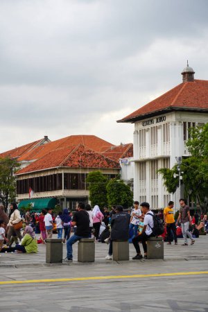 Foto de Atractiva vista trasera de los turistas locales disfrutando de la vista del Museo Fatahillah en la plaza Kota Tua el 23 de enero de 2023 - Imagen libre de derechos
