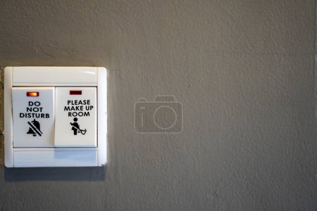Téléchargez les photos : Un interrupteur lumineux avec un panneau indiquant s'il vous plaît ne pas déranger - en image libre de droit