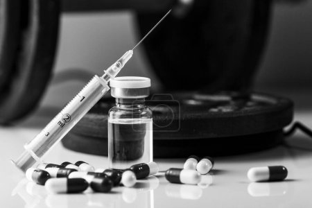 Hanteln, Spritze mit Nadel, Tabletten und Fläschchen mit Steroiden. Illegales Doping im Sport