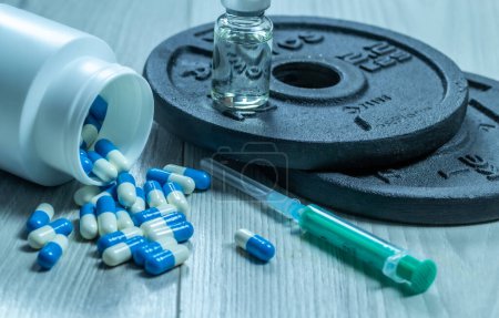  Spritze mit Nadel, Pillen und Fläschchen mit Steroiden. Illegales Doping im Sport