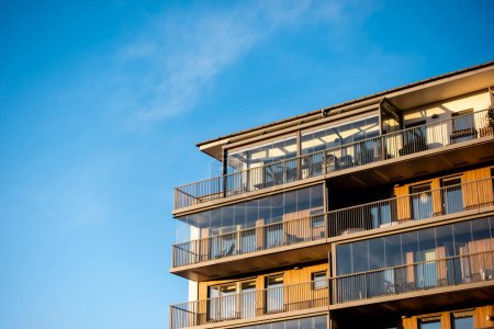 Téléchargez les photos : Propriété résidentielle et immeuble d'habitation moderne avec des maisons familiales dans une construction de maison nouvellement construite dans la ville coucher de soleil contre un ciel bleu - en image libre de droit