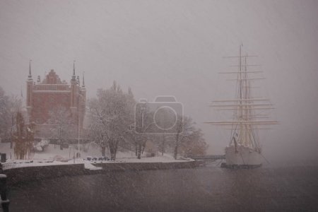 Téléchargez les photos : Skeppsholmen îlot dans la neige Stockholm en hiver avec af Chapman voilier amarré avec chute de neige - en image libre de droit