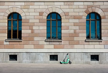 Photo for Modern electric scooter leaning on facade of historic stone building as a contrast of old and new - Royalty Free Image
