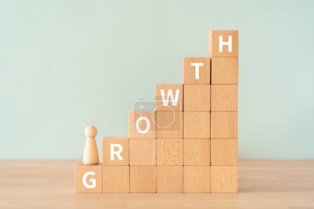 Wooden blocks with "GROWTH" text of concept and a human toy.