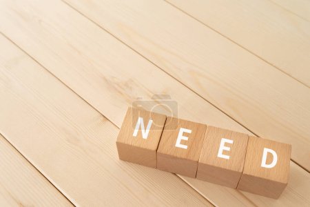 Photo for Wooden blocks with "NEED" text of concept on the wooden floor. - Royalty Free Image