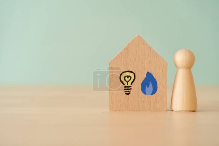 Photo for A wooden block in house shape with light bulb icon on wooden table - Royalty Free Image