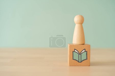 Photo for A wooden block with a book icon on wooden table - Royalty Free Image