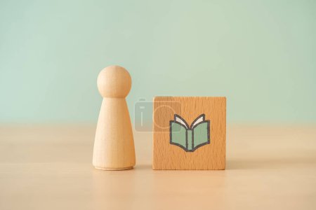 Foto de Un bloque de madera con un icono de libro en la mesa de madera - Imagen libre de derechos