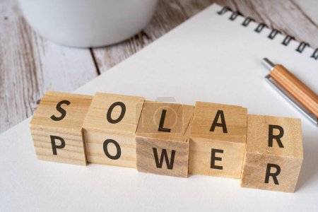 Photo for Wooden blocks with "SOLAR" and "POWER" text of concept and coins. - Royalty Free Image