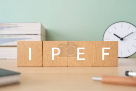 Photo for Wooden blocks with "IPEF" text of concept, pens, notebooks, and books. - Royalty Free Image