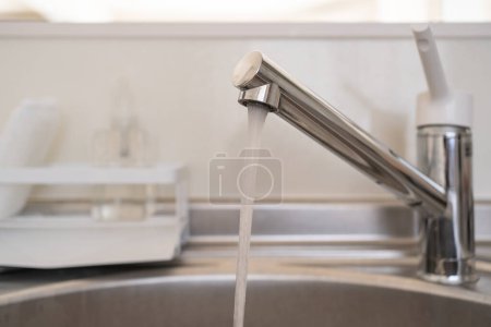 Photo for Running water from the faucet in the kitchen. - Royalty Free Image