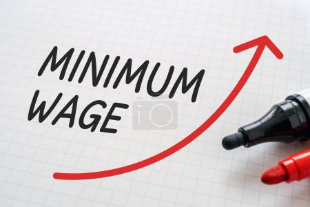 White paper written "MINIMUM WAGE" with markers.