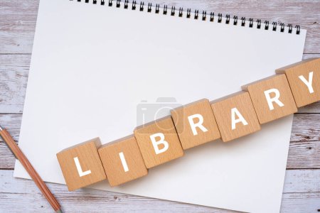 Photo for Wooden blocks with "LIBRARY" text of concept, a pen, and a notebook. - Royalty Free Image