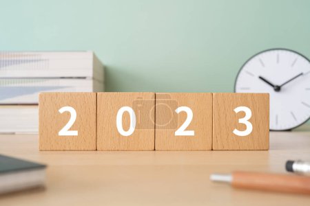 Photo for Wooden blocks with "2023" text of concept, pens, notebooks, and books. - Royalty Free Image