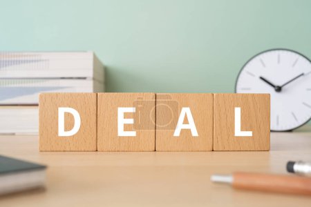 Photo for Wooden blocks with "DEAL" text of concept, pens, notebooks, and books. - Royalty Free Image