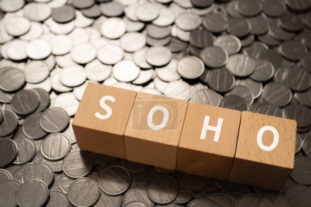 Foto de Bloques de madera con texto "SOHO" de concepto y monedas. - Imagen libre de derechos