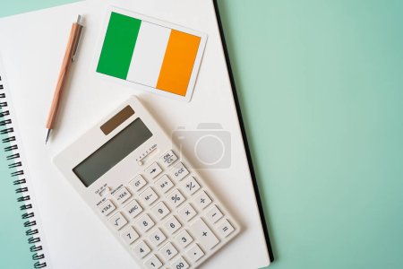 Téléchargez les photos : Drapeau Irlande, calculatrice, stylo et bloc-notes sur la table - en image libre de droit