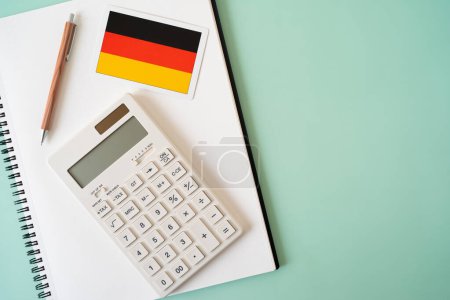 Foto de Bandera de Alemania, calculadora, pluma y cuaderno en la mesa - Imagen libre de derechos