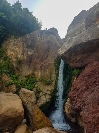 Foto de Zarka Cascada, una joya escondida en las montañas de Marruecos. La cascada es una hermosa cascada de agua que fluye por un acantilado empinado. El agua está rodeada de exuberante vegetación y rocas - Imagen libre de derechos