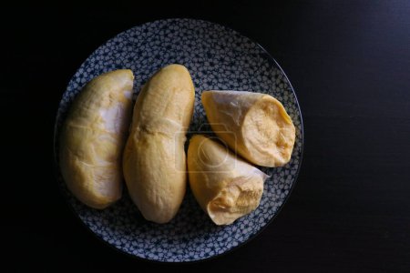 Téléchargez les photos : Pulpe durian jaune brillant sur plaque de porcelaine - en image libre de droit