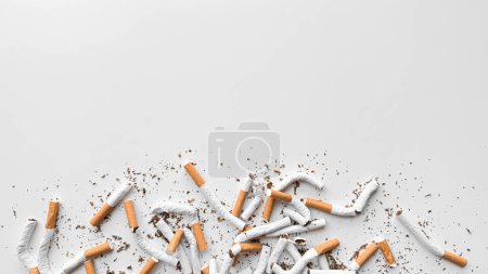 Weggeworfene zerquetschte Zigaretten und verstreuter Tabak auf weißem Hintergrund, der das Aufhören und das Ende des Rauchens mit Kopierraum darstellt. Kein Tabaktag. Hochwertiges Foto