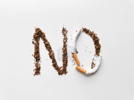 Mot NON créé avec du tabac et cigarette cassée sur fond blanc pour anti-tabac et concept de santé. Pas de journée tabac. Photo de haute qualité