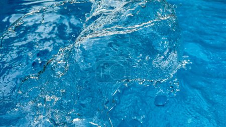 Hintergrund dynamisches Spritzen klaren Wassers, das eine wirbelnde Welle in blauem Wasser mit in Bewegung schwebenden Tröpfchen erzeugt. Konzept für sauberes Wasser. Hochwertiges Foto