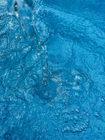 Arrière-plan éclaboussure dynamique d'eau claire créant une vague tourbillonnante dans l'eau bleue avec des gouttelettes suspendues en mouvement. Concept d'eau propre. Photo de haute qualité