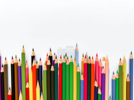 Téléchargez les photos : Crayons de couleur assortis alignés sur fond blanc avec de l'espace pour le texte. Concept créatif pour l'art, l'éducation et le design bannière publicitaire pour les produits scolaires avec espace vide. Photo de haute qualité - en image libre de droit