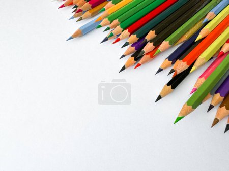 Diagonale Anordnung von scharfen Buntstiften auf weißem Hintergrund mit leerem Raum für Text. Künstlerisches Konzept für Schreibwaren, Bildung, Design oder Werbebanner für Schulprodukte.