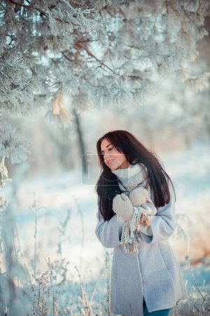 Foto de Retrato de hermosa chica morena en bufanda caliente al aire libre en el bosque de heladas de invierno.. - Imagen libre de derechos