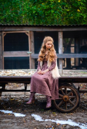 Photo for Portrait of beautiful blonde curl girl in medieval dress and fur vest on  nature. Young worker in rural scene.Warm colorful art work. - Royalty Free Image