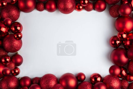 Foto de Enmarcado de bolas rojas de Navidad de diferentes tamaños y texturas sobre un fondo blanco, espacio de copia - Imagen libre de derechos