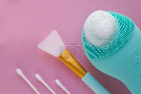 Téléchargez les photos : Silicone face brush and different cosmetic devices on a pink background. High quality photo - en image libre de droit