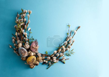Photo for Bouquet of spring willow decorated with Easter eggs on a blue background copy space - Royalty Free Image