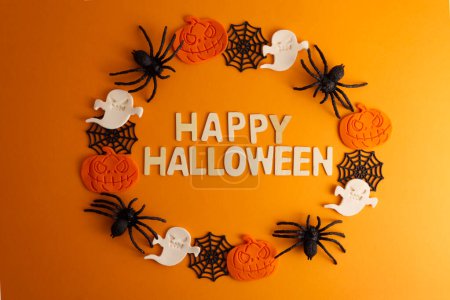 Happy Halloween Text auf orangefarbenem Hintergrund mit Dekor Spinne, Spinnweben, Geist und Kürbis