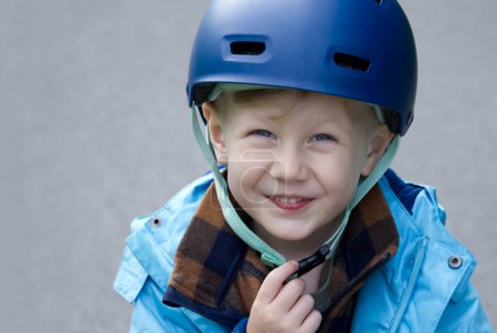 Little boy in a bicycle helmet smiles looking at the camera