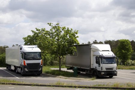Photo for Two warehouse trucks are parked at a truck stop rest area near the autobahn. High quality photo - Royalty Free Image