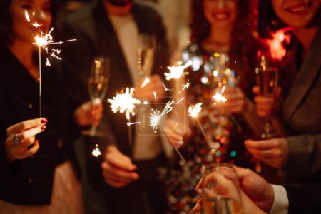 Photo for Sparkling sparklers in the hands of friends.Group of people holding sparklers at party. Winter holidays, vacation, relax and lifestyle concept. - Royalty Free Image