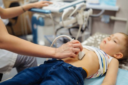 Photo for Little boy undergoing  ultrasound at clinic. doctor making abdominal cavity sonogram for child - Royalty Free Image