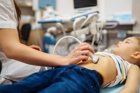 Photo for Little boy undergoing  ultrasound at clinic. doctor making abdominal cavity sonogram for child - Royalty Free Image